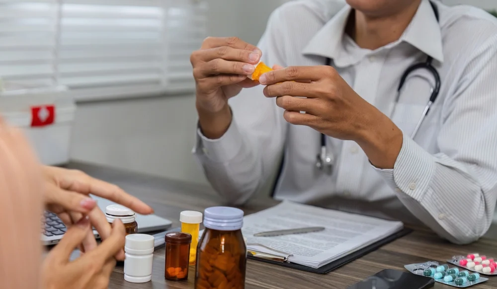 a doctor holding a pill / Top Benefits and Challenges in Medication Therapy Management (MTM) / Benefits of Medication Therapy Management (MTM) / Improved Medication Adherence / Reduced Risk of Adverse Drug Events (ADEs) / Personalized Medication Plans for Chronic Disease Management / Cost Savings for Patients and the Healthcare System / Enhanced Patient Satisfaction and Empowerment / Challenges in Medication Therapy Management (MTM) / Lack of Awareness and Understanding / Financial Barriers and Limited Reimbursement / Access to MTM Services / Fragmentation of Care / Time Constraints for Healthcare Providers / Pharmacy Care RX Services Palm Beach / Free Delivery