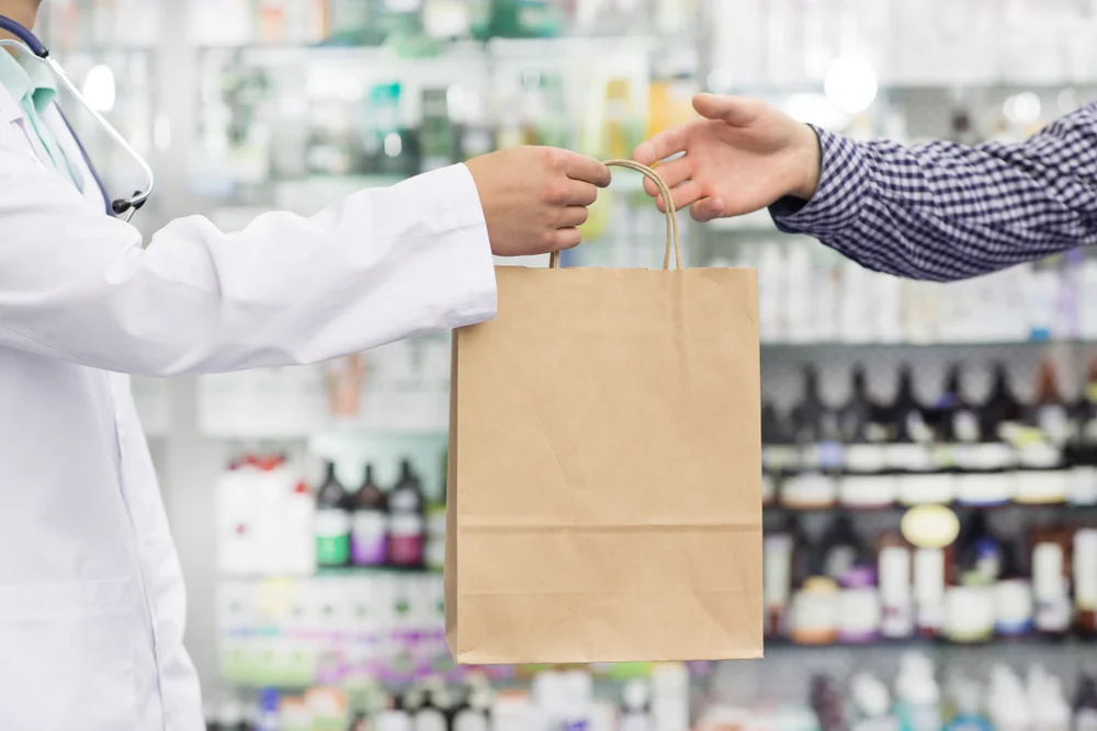 a person handing a bag to another person / What is White Bagging? / Understanding White Bagging / How Does White Bagging Work? / Why is White Bagging Used? / Improved Medication Management / Better Access to Specialty Drugs / White Bagging vs. Brown Bagging / The Future of White Bagging / Pharmacy CareRx / Florida