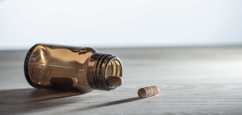 A glass vial with several medicines lies on a table