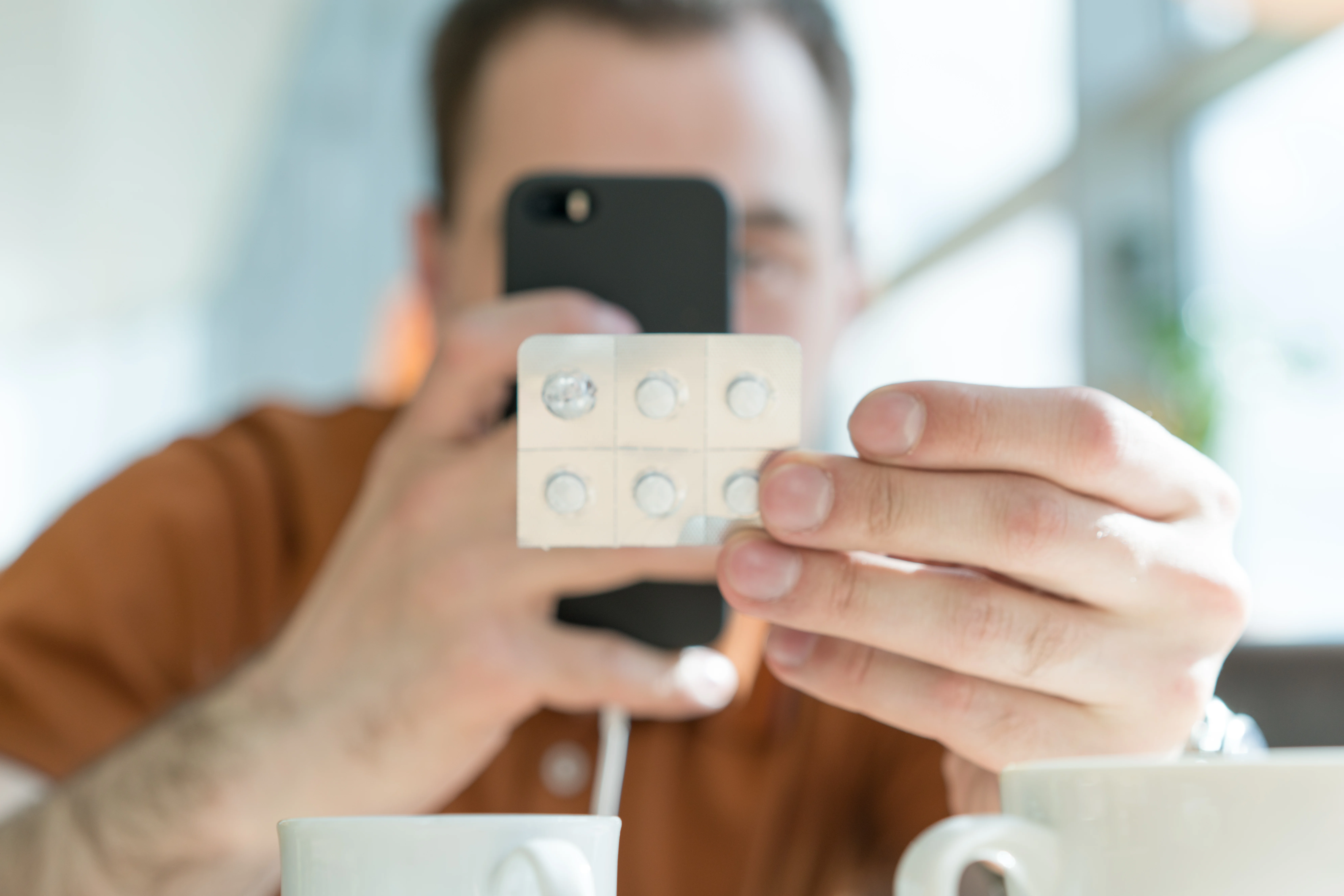 a young adult man Looking at mobile phone because he missed a Dose of Methylprednisolone