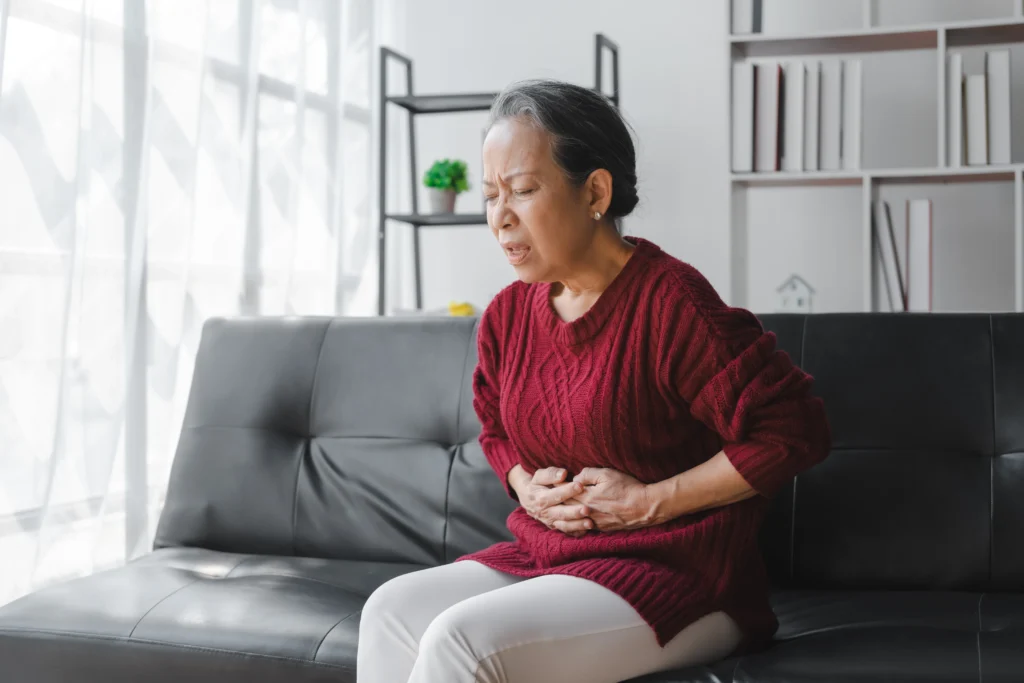 A Woman Experiencing Ulcer pain due to Side effects of missing a dose of omeprazole.