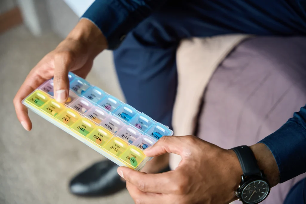 A man setting Prozac Pills in a  pill organizer to avoid missing a dose of Prozac
