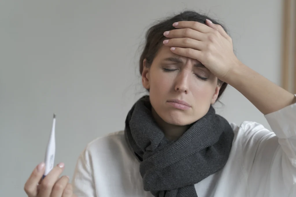 A woman feeling pain and fever like symptoms due to Side Effects of Missing a Dose of Metronidazole.
