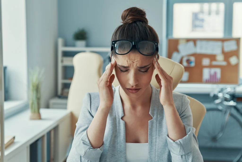 A woman experiencing headache due to Side Effects of Missing a Dose of Sertraline.