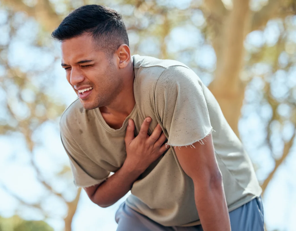 Person experiencing chest pain that may indicate a blood clot after missing a warfarin dose.