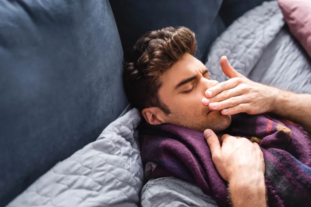 Man experiencing nasal congestion while resting in bed