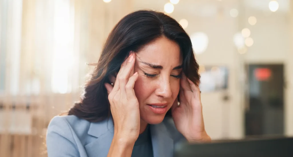 Woman experiencing headache and discomfort as a possible methylprednisolone side effect