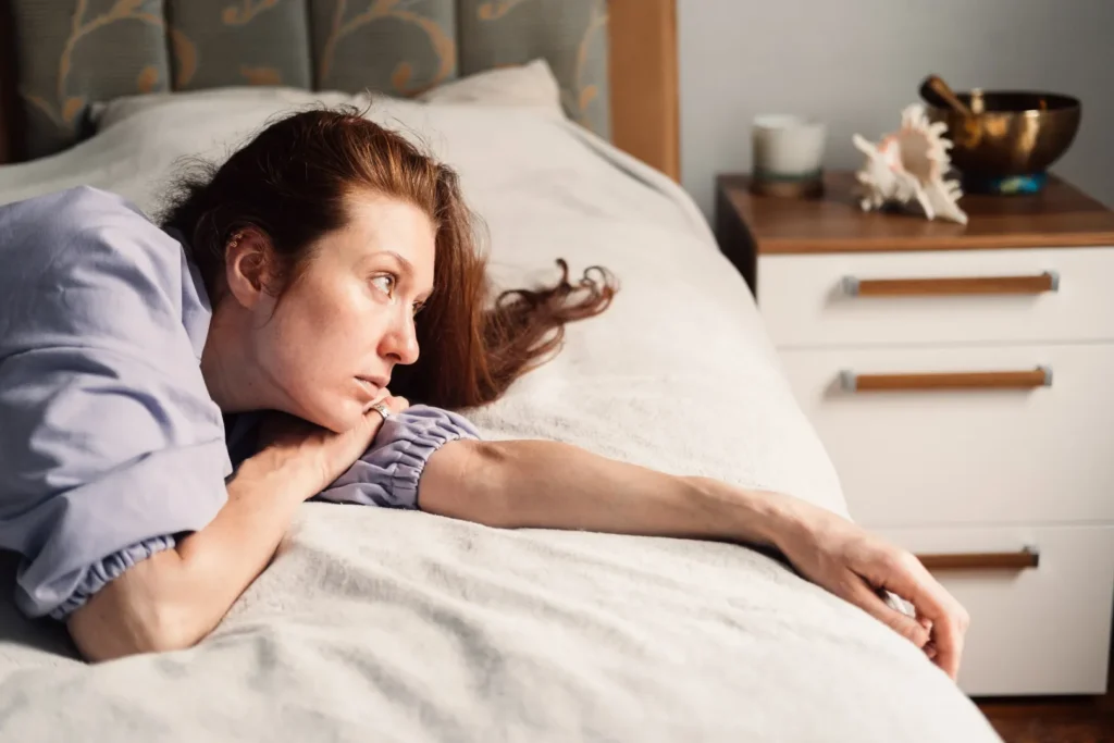 Woman lying awake in bed with difficulty sleeping while taking methylprednisolone