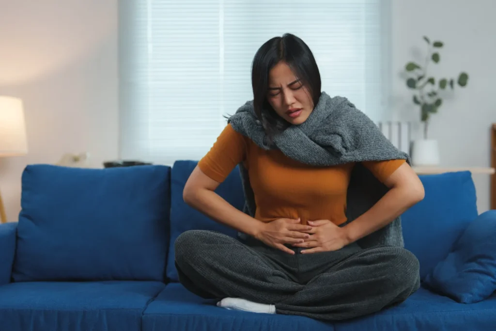 Woman holding her stomach while experiencing stomach upset from methylprednisolone