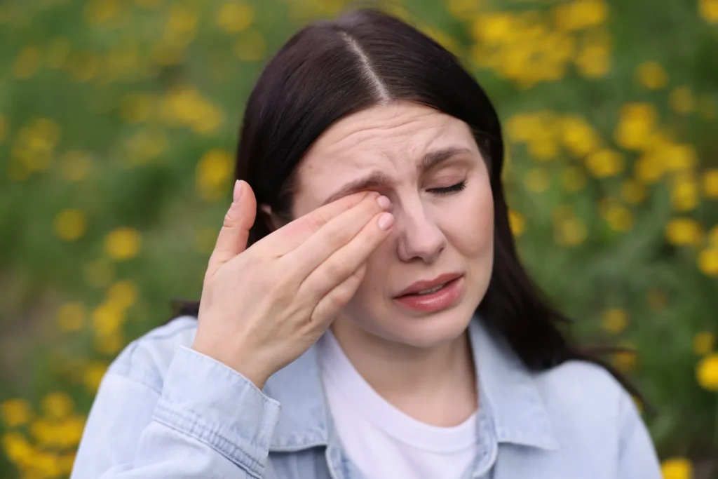 Woman rubbing an itchy eye caused by allergy symptoms