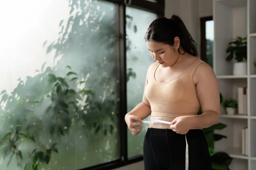 A woman measuring her waist to check if she is gaining weight.