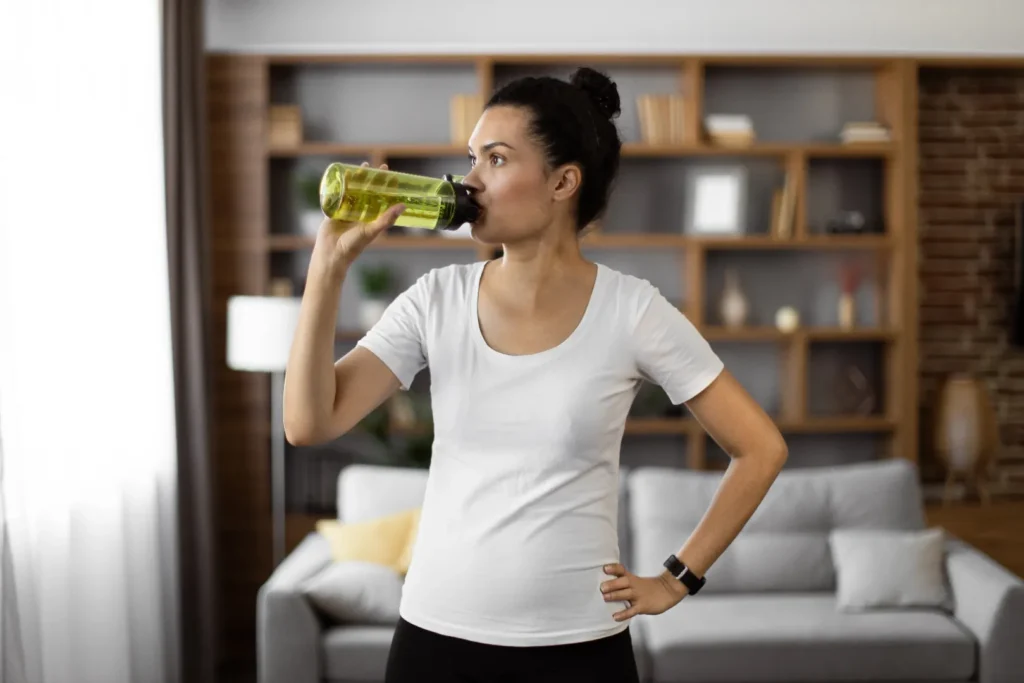 Woman drinking fluids while experiencing diarrhea.